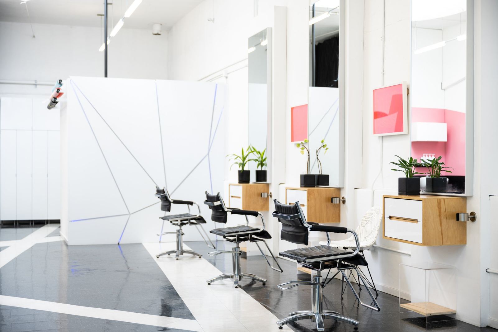 Styling chairs, mirrors and plants beside a geometric white wall